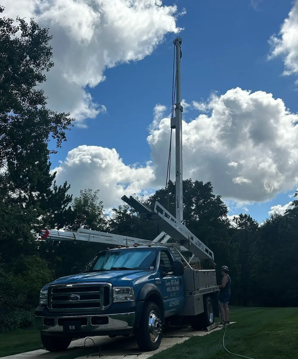 Lauren McCullough well service truck with its drilling derrick raised at a job site