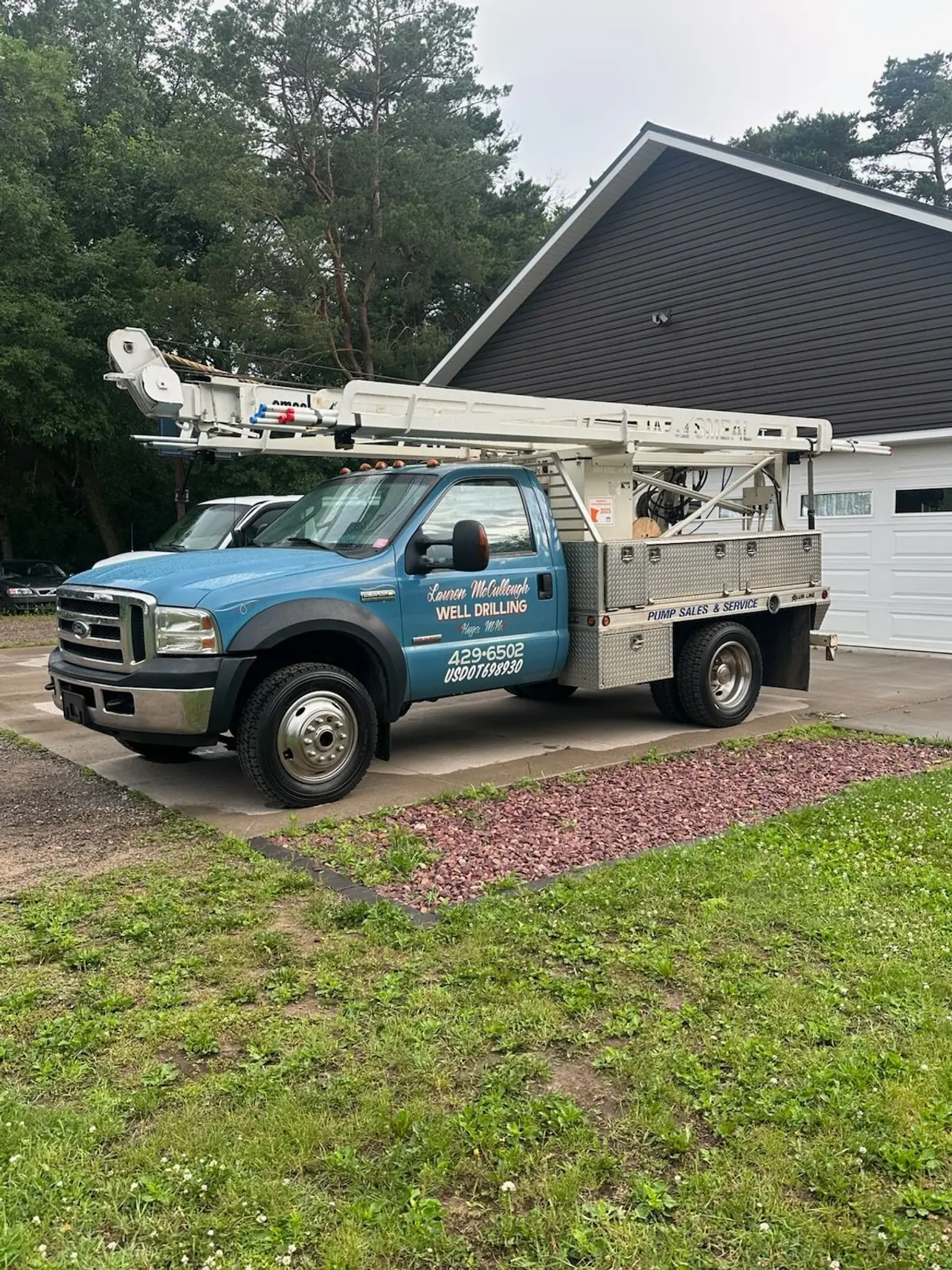 Service truck parked in a driveway beside a house, ready for a pump job