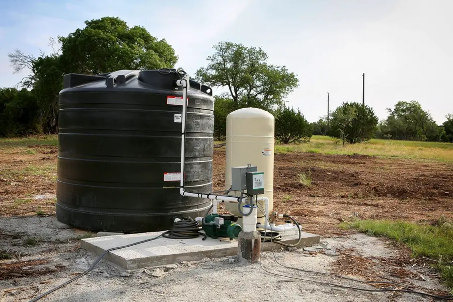 Upgraded well system with a large storage tank and pressure tank installed outdoors