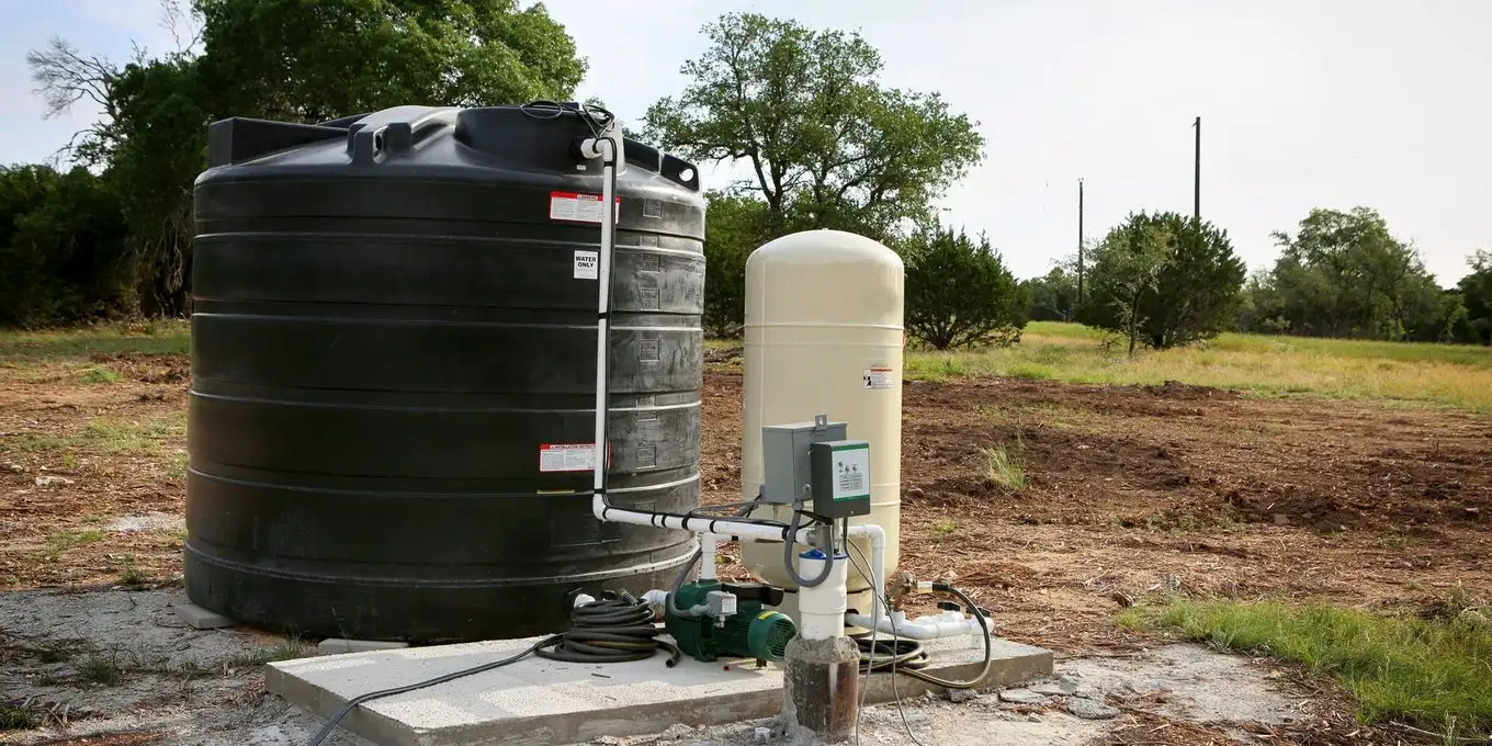 Upgraded well system with a large storage tank and pressure tank installed outdoors